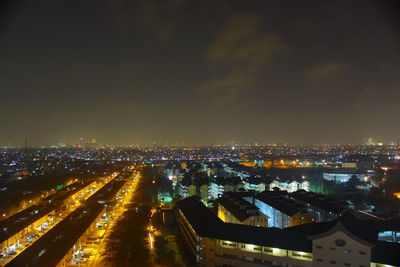 Illuminated cityscape against sky at night