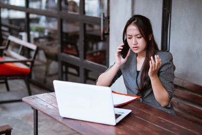 Young woman using laptop at table