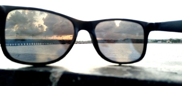 Close-up of sunglasses against sky