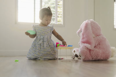 Cute girl playing with toy at home