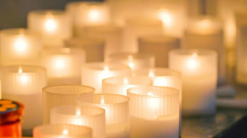 Close-up of illuminated tea light candles in temple