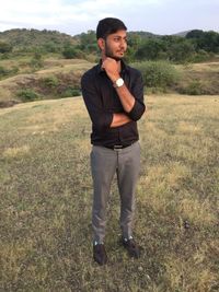 Portrait of young man standing on field