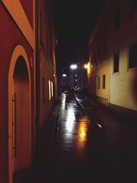 Illuminated walkway in city at night