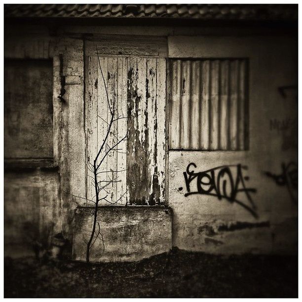 architecture, built structure, building exterior, text, wall - building feature, graffiti, western script, door, transfer print, wall, window, auto post production filter, closed, communication, brick wall, abandoned, house, weathered, old, day