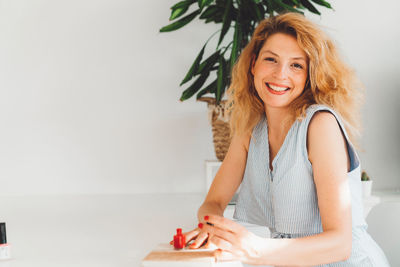 Portrait of young woman sitting on bed at home