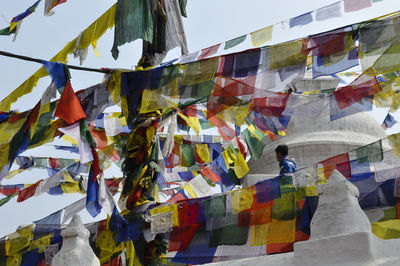 Multi colored flags hanging against blue sky