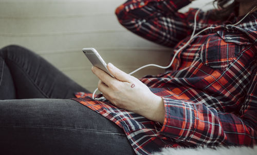 Low section of woman using mobile phone at home