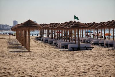 Chairs on beach against clear sky