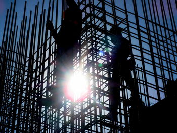 Low angle view of silhouette person on metal structure against sky