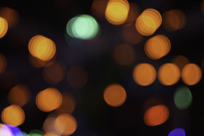 Defocused image of illuminated christmas lights at night