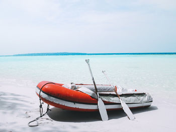 Boat moored on shore against sky