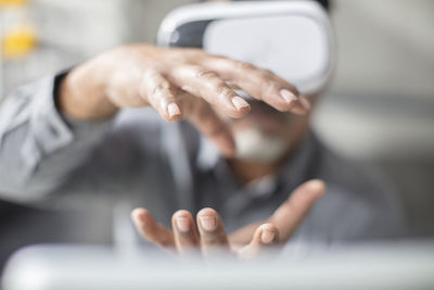 Man shaping with his hands wearing vr glasses in office