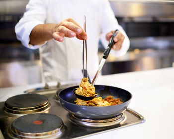 Midsection of man preparing food in kitchen