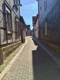 Cobblestone street amidst buildings against sky