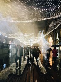 People standing in illuminated city at night