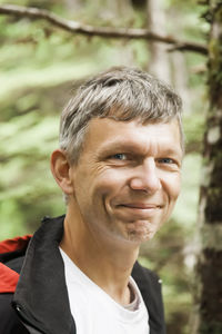 Close-up portrait of smiling man in forest