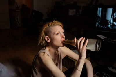 Young woman drinking at home