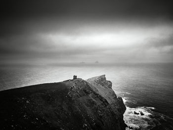 Scenic view of rocks on sea against sky