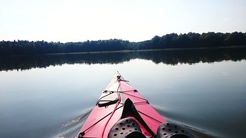 Boat moored on lake against sky