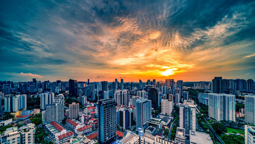 Aerial view of buildings in city against sky during sunset