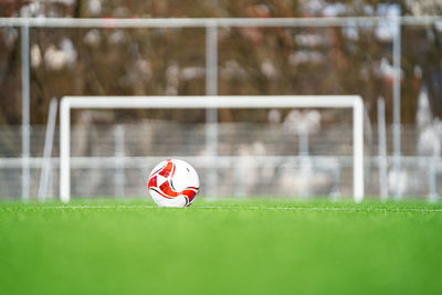 Red ball playing on soccer field