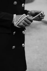 Close-up of hand holding cross against blurred background