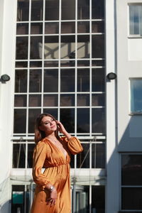 Full length of woman standing against window