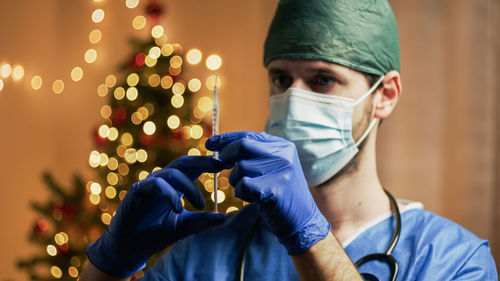 Doctor with vaccine on christmas background