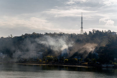 Scenic view of river by buildings against sky