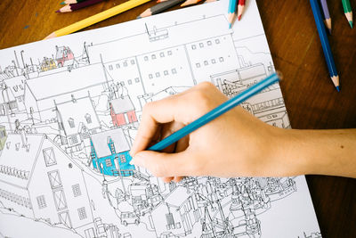 Cropped image of person working on blueprint