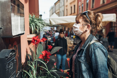 Close-up of woman wearing mask standing outdoors