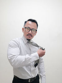 Portrait of businessman standing against white background