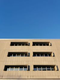 Low angle view of modern building against clear blue sky