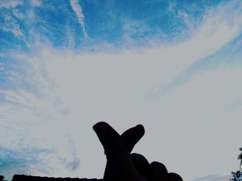 Low angle view of silhouette hand against sky