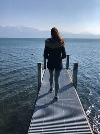 Rear view of woman looking at sea against sky