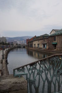 Bridge over river against buildings in city
