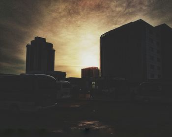 Buildings in city against sky during sunset