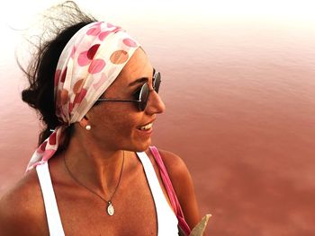 High angle view of smiling woman looking away while standing at beach