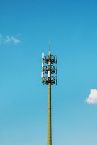 Low angle view of electricity pylon against blue sky