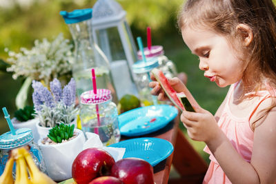 Cute girl eating watermelon in yard