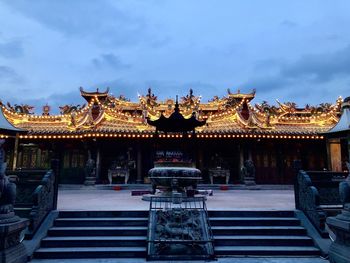 Illuminated temple building against sky