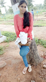 Portrait of happy woman standing against tree