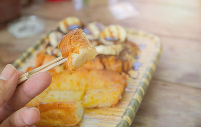 Close-up of hand holding bread on table