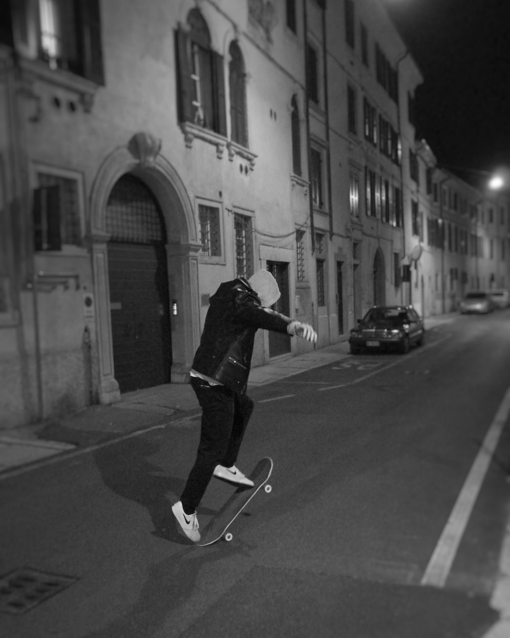 MAN SKATEBOARDING ON ROAD IN CITY