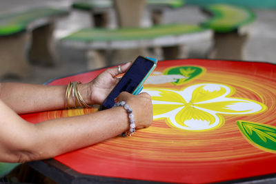 High angle view of woman holding painting on table