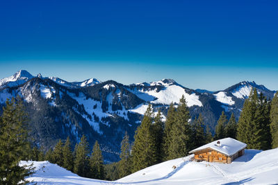 Scenic view of snowcapped mountains against clear blue sky