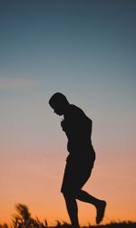 Silhouette of boy standing against clear sky