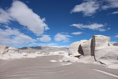 Rock formations on beach against sky