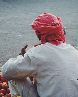 Rear view of man selling tomatoes at street market