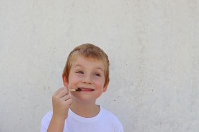 Portrait of young woman with eyes closed against wall